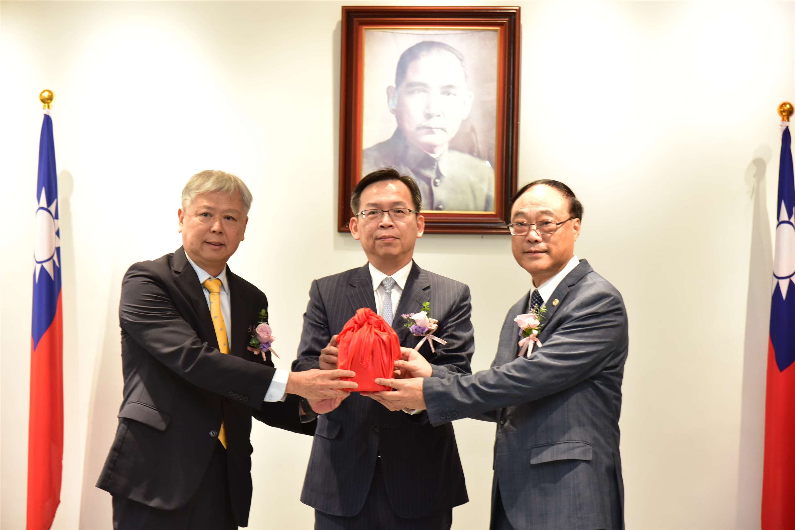 台灣港務公司原任董事長李賢義(左)13日在交通部次長林國顯(中)見證下，將董座印信交給新任董事長、前觀光署長周永暉(右)。(圖：台灣港務公司提供)