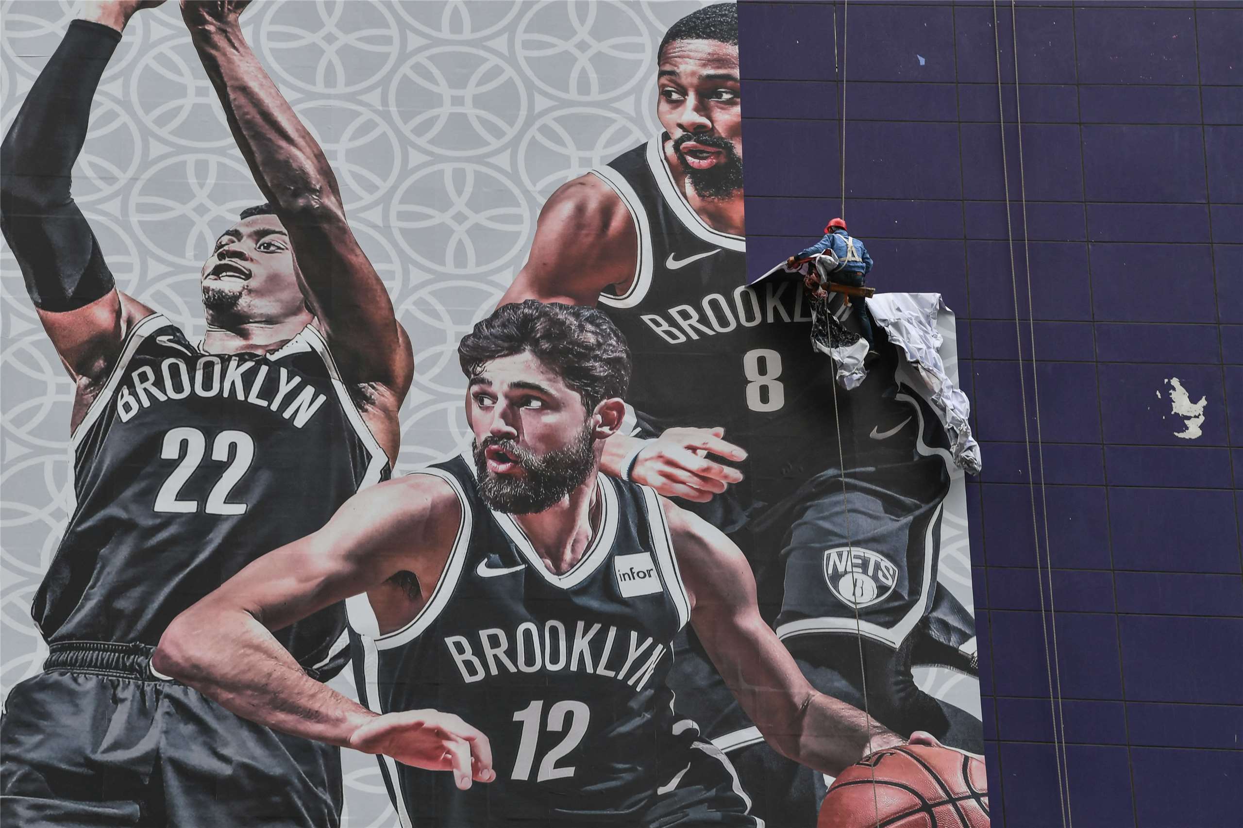 美國職業籃球(NBA)時隔6年重返獲利豐厚的中國市場。圖攝於2019年10月9日，一名工人在上海的一棟建築物上拆除NBA季前賽的宣傳橫幅。