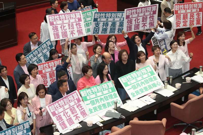 立法院會17日三讀通過「中央政府因應國際情勢強化經濟社會及民生國安韌性特別預算案」，其中包含普發現金1萬元預算新台幣2360億元。圖為民進黨立委拿著手舉牌呼口號。