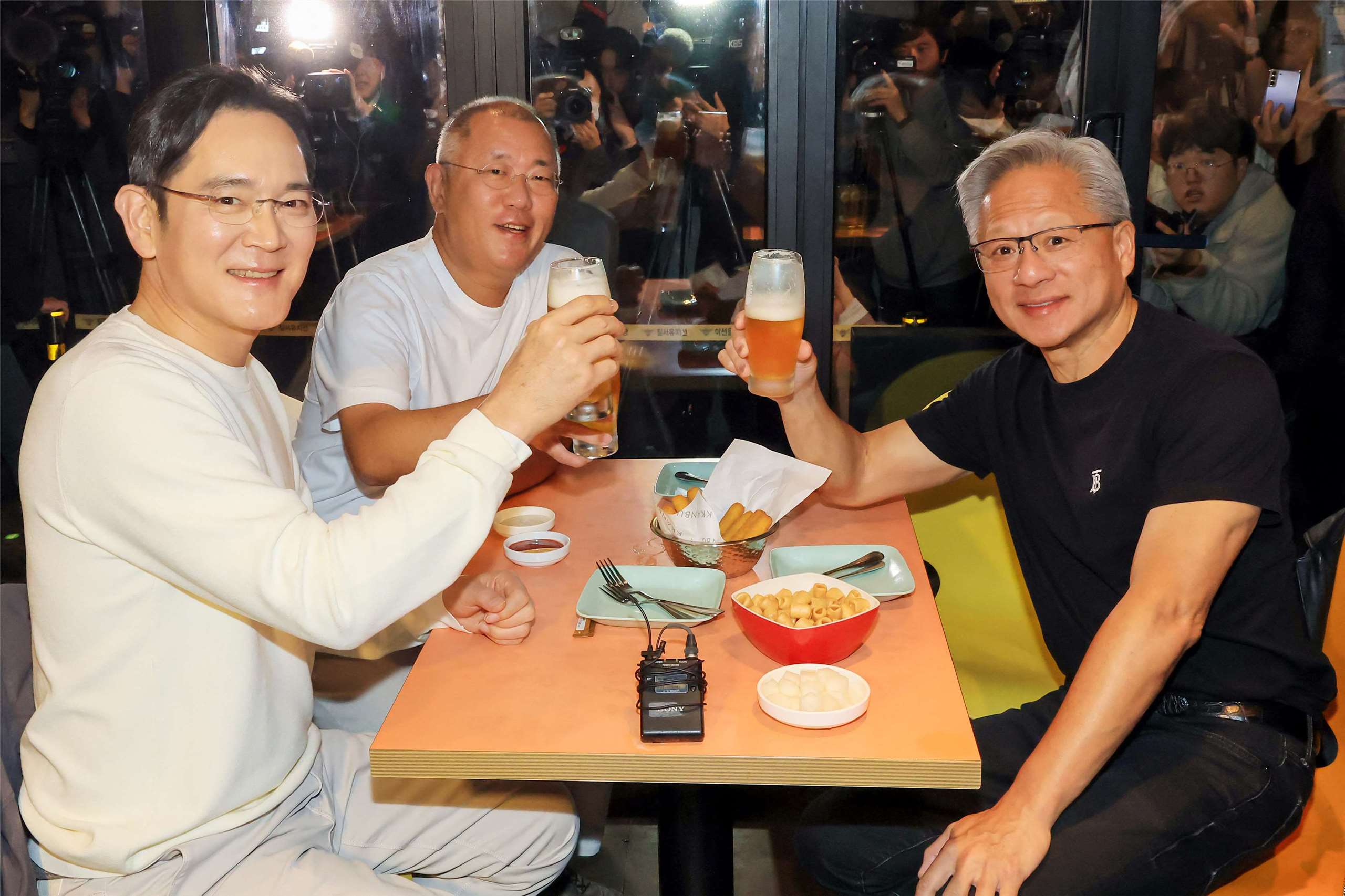 正在南韓參加APEC企業領袖峰會的輝達執行長黃仁勳（右）與三星電子會長李在鎔、現代汽車集團會長鄭義宣，30日在首爾一家炸雞餐廳共進晚餐並舉杯合影。 (AFP)