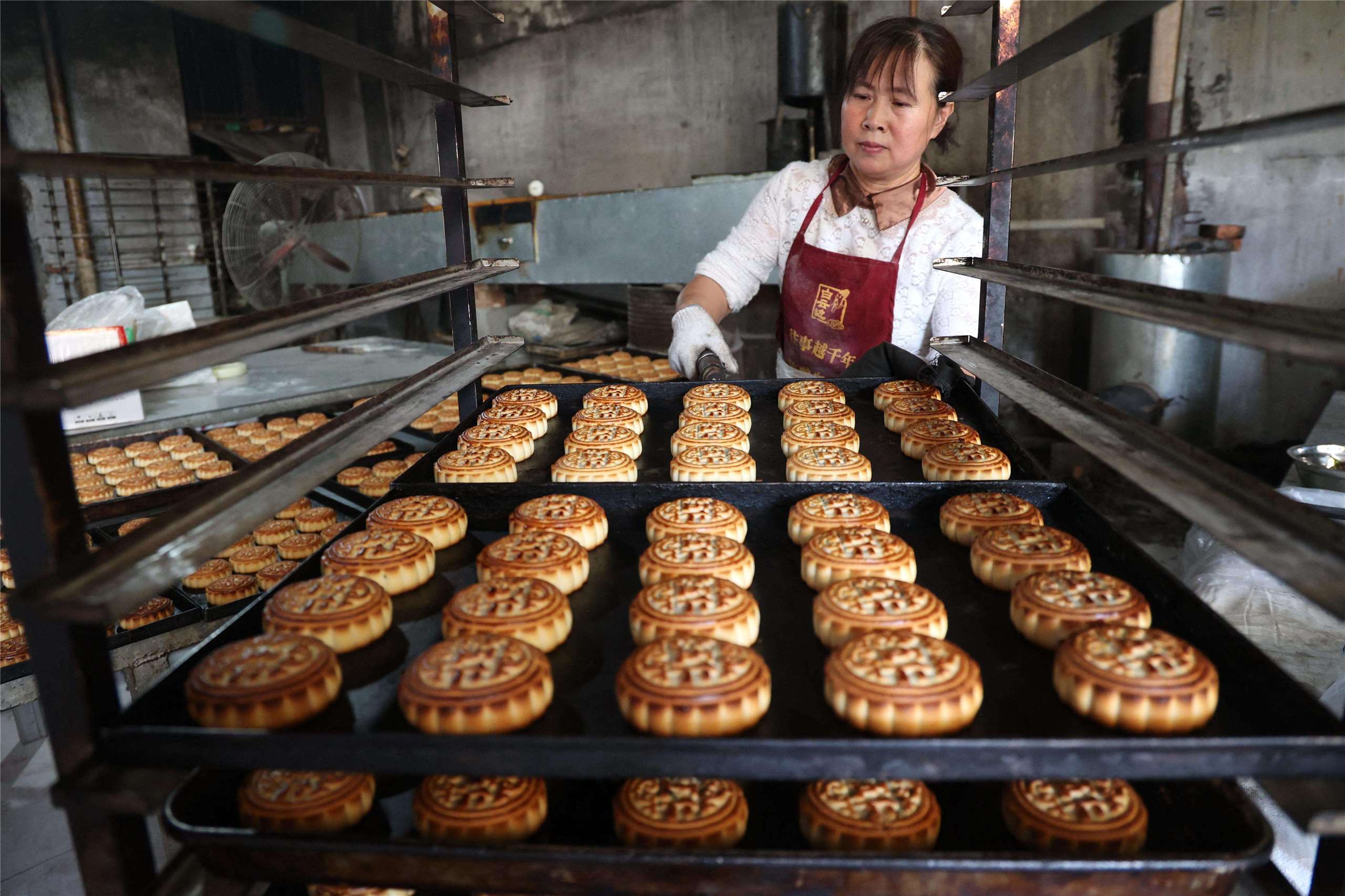 中國山東省濱州市一家食品工廠員工正在製作月餅。(AFP)