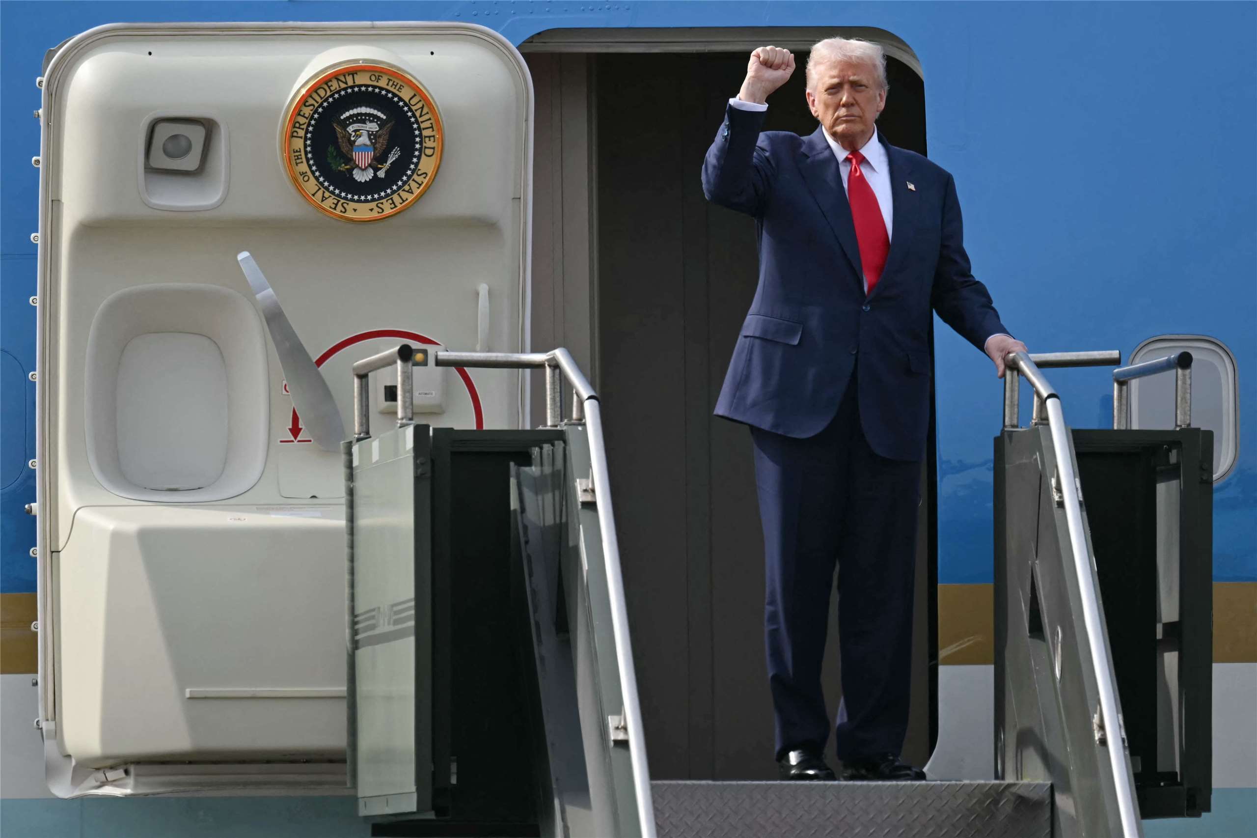 美國總統川普與中國國家主席習近平會談後，登上空軍一號時做出手勢。