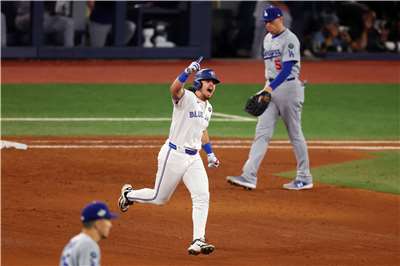 多倫多藍鳥隊47號球員艾迪森·巴格(Addison Barger)(圖中)在MLB世界大賽中，對陣洛杉磯道奇隊的首場比賽中擊出滿貫本壘打後開心繞行壘包返回本壘。(AFP)