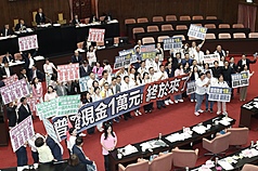 立法院會17日三讀通過「中央政府因應國際情勢強化
經濟社會及民生國安韌性特別預算案」，其中包含普
發現金1萬元預算新台幣2360億元。圖為朝野立委在
議場內拿著手舉牌呼口號。(資料照片)
