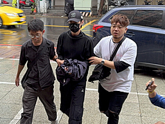 藝人閃兵案延燒，新北檢警21日展開第3波搜索，永和警分局上午拘提棒棒堂成員小杰（中）等4人到
案，4人皆被上銬步入警局，引發議論。 (圖：中央社)