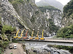 花蓮立霧溪燕子口堰塞湖29日上午潰決，洪峰過後無災情發生，水位順利下降至原河道水位，林業及自然保育署宣布解除警戒，公路局下午5時開放中橫通行，恢復台8線5時段放行。圖為施工團隊大型挖土機一字排開向山致敬。（林業及自然保育署花蓮分署提供提供）