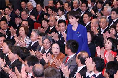 高市早苗在贏得自民黨總裁選舉後，起立致意。