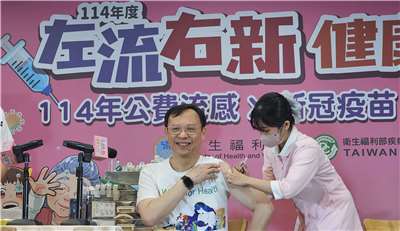 衛福部長石崇良1日挽袖率先施打「左流右新」。(劉品希 攝)