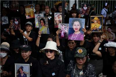 民眾手持已故前王太后詩麗吉（Sirikit）的肖像。