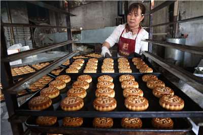 中國山東省濱州市一家食品工廠員工正在製作月餅。(AFP)