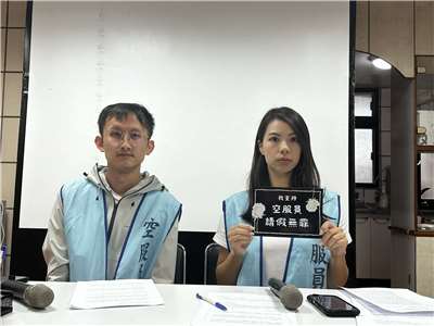 桃園市空服員職業工會理事周沛汝(右)拿著26日馬拉松的抗議標語。(楊雨青攝)