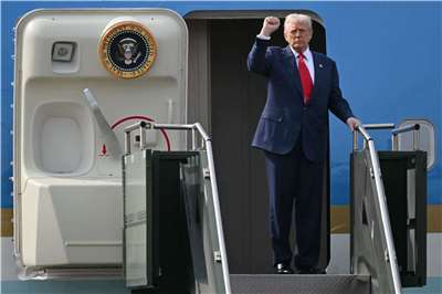 美國總統川普與中國國家主席習近平會談後，登上空軍一號時做出手勢。