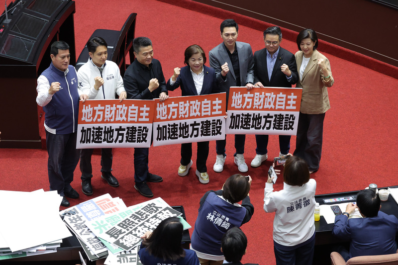 立法院14日下午院會再次三讀通過國民黨團版財政收支劃分法部分條文修正草案，國民黨立委顏寬恒（後左3）、楊瓊瓔（後左4）等人一同拿著「地方財政自主 加速地方建設」標語牌在場內開心合影。 (圖：中央社)