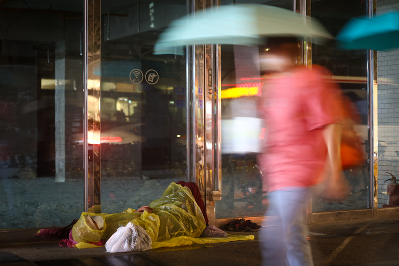 東北季風增強，北台灣氣溫率先開始下降、水氣增多，新北市板橋區街頭無家者穿上雨衣保暖。

