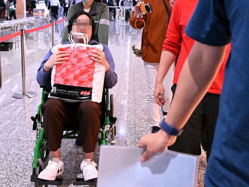 網傳不實訊息稱「法國BBC報導台灣捐贈80億歐元巨資交換演講」引關注，涉嫌發文的陳姓男子(左，坐輪椅者)12日搭機返台，刑事局派員到桃園國際機場請陳男協助釐清案情。(中央社)
