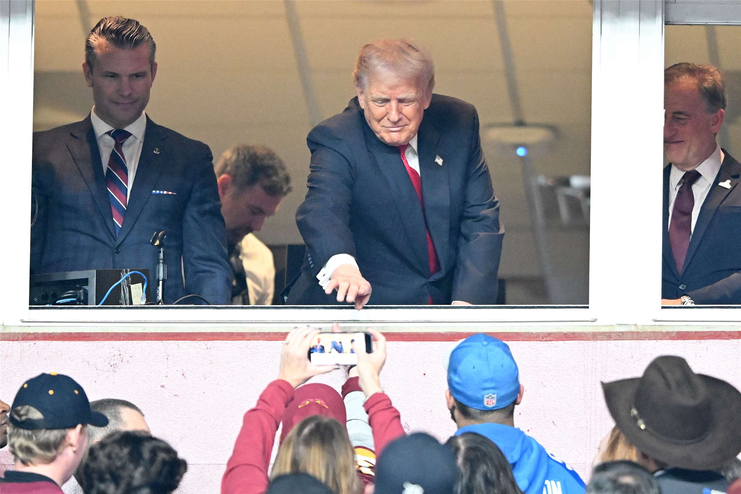 美國總統川普(中)9日親臨現場，觀賞職業美式足球聯盟華盛頓指揮官(Washington Commanders)和底特律雄獅(Detroit Lions)的比賽，川普並和球迷互動。