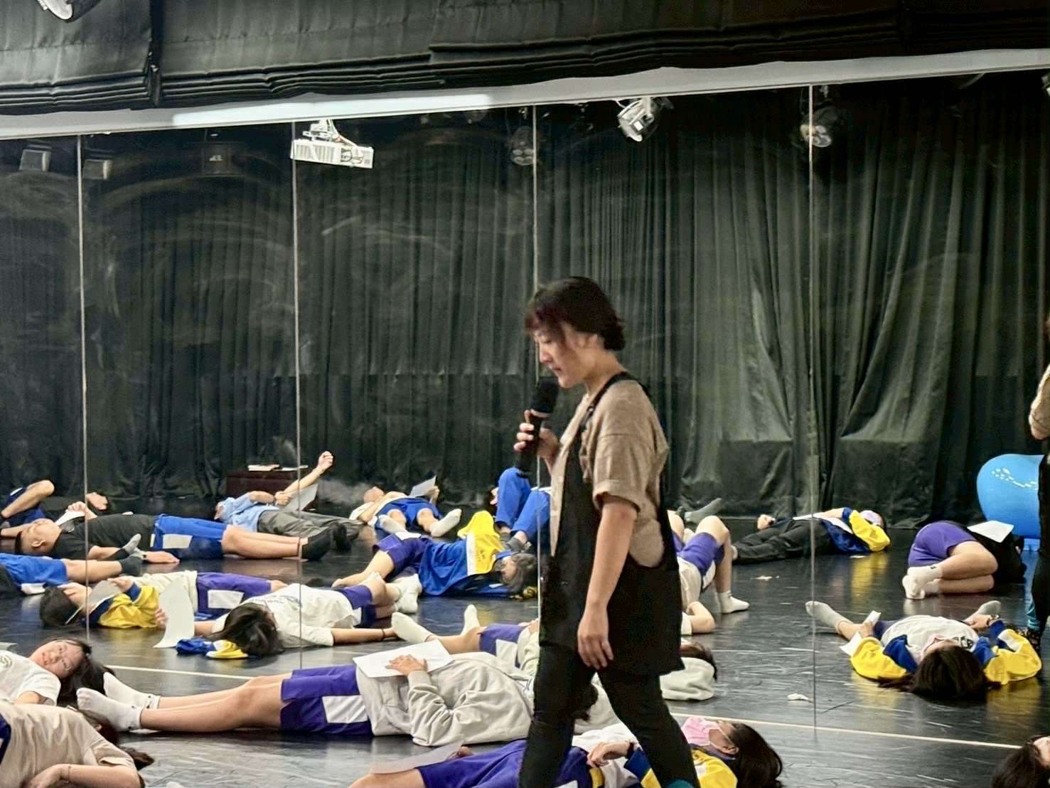 在表演藝術教室裡，沒有桌椅、四周圍都是鏡子，讓學生不太自在卻又開放的空間裡，去思考去想像