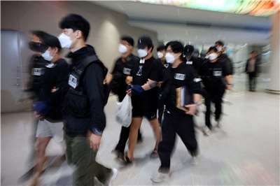 打擊跨國詐騙，南韓首次對東南亞詐團實施制裁。圖為警方護送在柬埔寨涉嫌參與網路詐騙集團的南韓籍遣返者。資料照。