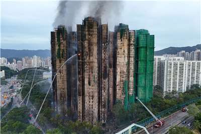 香港新界大埔宏福苑26日發生重大火災，造成128人死亡、約有200人失聯。圖為稍早前消防員向大樓射水滅火。