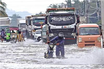 強烈颱風「鳳凰」(Fung-wong)逼近菲律賓，導致才剛剛遭遇海鷗颱風肆虐的民眾，再度繃緊神經。圖為民答那峨島道路已經因鳳凰帶來雨勢而出現淹水情況。(AFP)