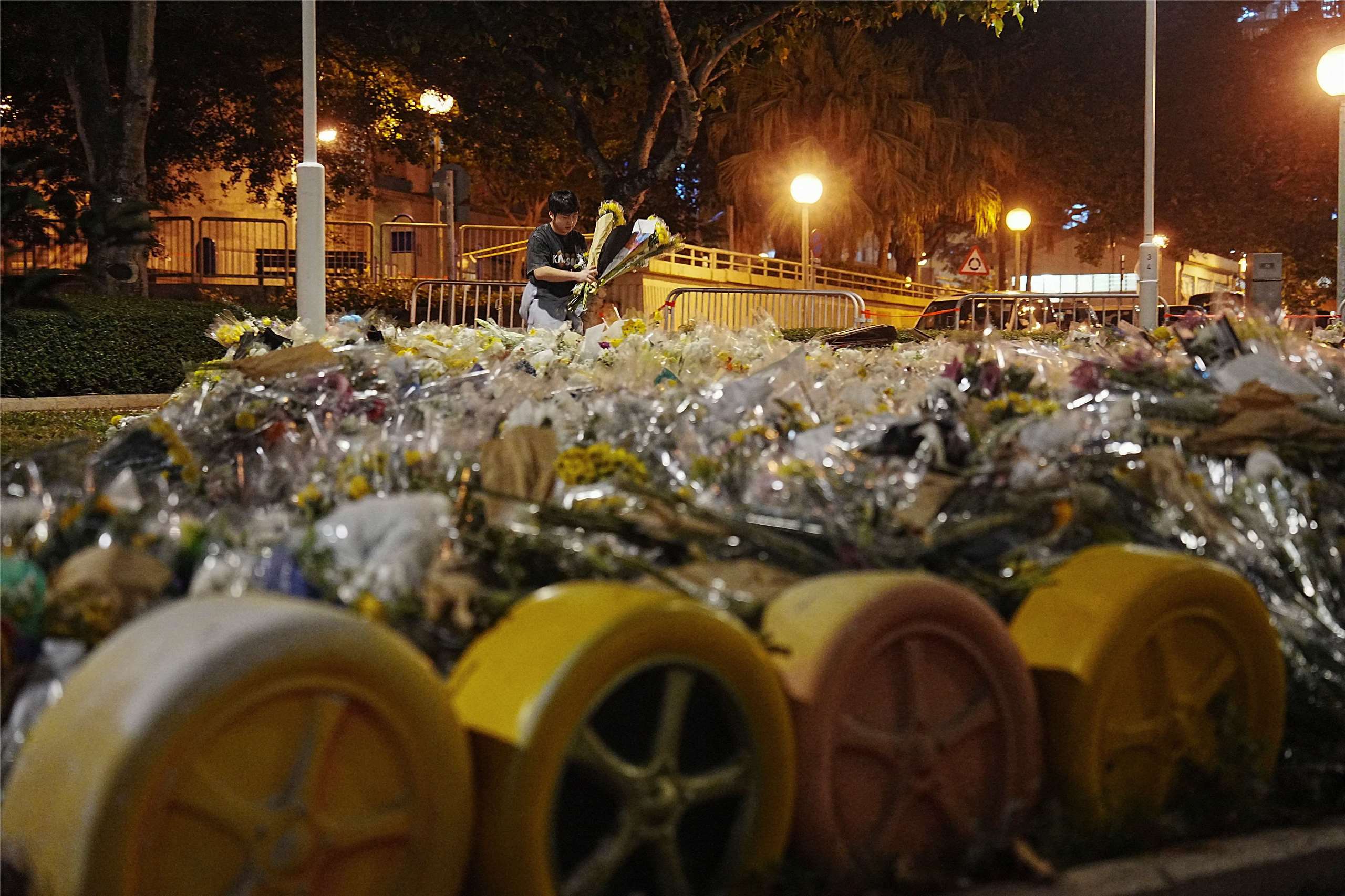 圖為香港立法會選舉期間，一名義工在大埔宏福苑附近整理悼念大火罹難者的鮮花。