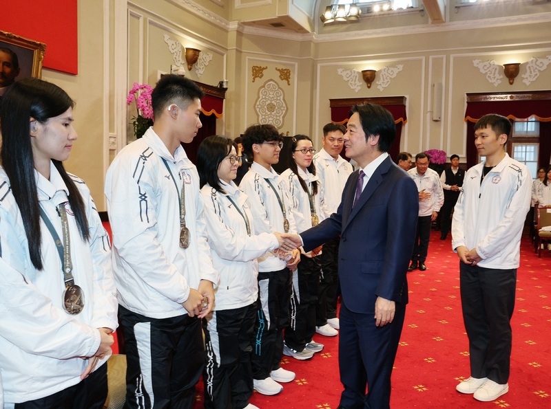 總統賴清德（前右）2日在總統府接見「2025年東京第25屆達福林匹克運動會」台灣代表團選手、教練及隊職員，運動部長李洋（後右）也陪同在側。
