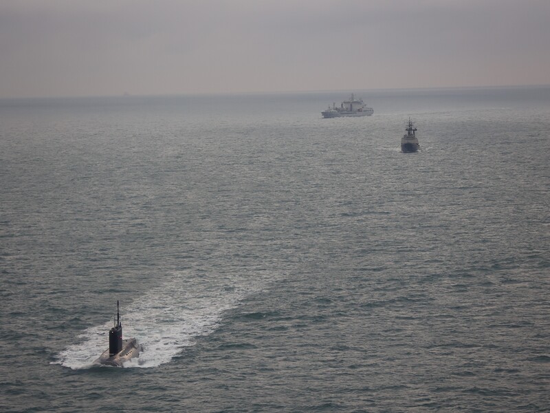 在一艘拖船伴隨下，俄羅斯潛艦近日再度現蹤英國周邊水域，英國出動一架海軍「梅林」反潛直升機和一艘油料補給船伴航監控。（英國海軍提供）
