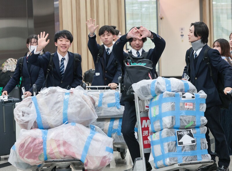 擁有「翡翠騎士」之稱的日本東京農業大學第二高等學校吹奏樂部17日晚間抵達台北松山機場，看見媒體熱情比出愛心手勢。