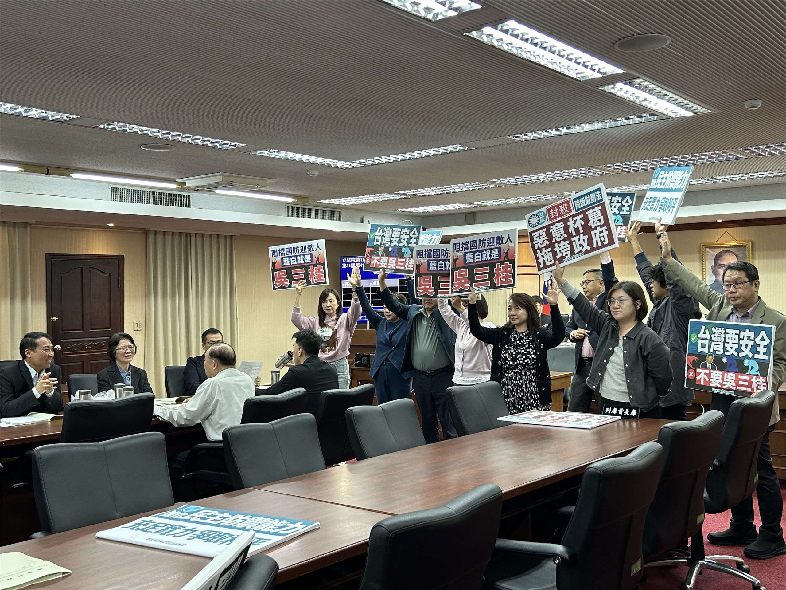 立法院程序委員會2日開會討論5日、9日院會議程，國民黨團提議把1.25兆國防特別條例暫緩列案，民進黨團高舉「阻擋國防迎敵人，藍白就是吳三桂」牌子抗議，呼籲藍、白立委別擋國防預算。(趙婉淳 攝)