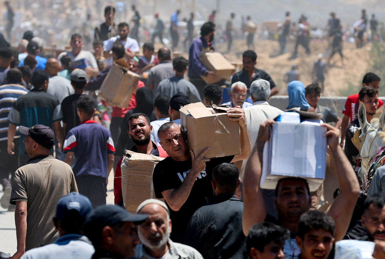 以色列30日宣布將從明年起，暫停向20多個人道組織發放在加薩走廊(Gaza Strip)的運作許可。圖為巴勒斯坦人從人道組織取得援助物資資料照。(路透社/達志影像)