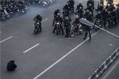 示威者坐路中擋騎車警察，伊朗「天安門時刻」網路瘋傳。 (圖:翻拍X平台)