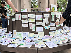 香港宏福苑26日發生奪命大火，民間在悲痛中自發支援、呼籲徹查原因與責任。圖為市民在大火附近公園的坐椅貼上悼念卡。