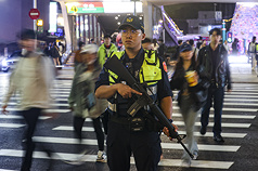 男子張文19日接連於捷運台北車站地下通道、中山站外丟擲煙霧彈、持刀傷人，之後闖入百貨墜樓不治。圖為中山站外晚間有員警持長槍加強戒備。
（珍惜生命，自殺不能解決問題，生命一定可以找到出路。若須諮商或相關協助，可撥衛福部專線「1925」、生命線專線「1995」或張老師服務專線「1980」。）
