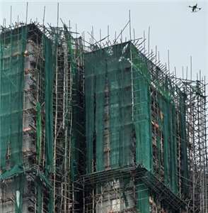 香港大埔宏福苑大火慘劇發生後，由於有證據顯示部 分棚網在阻燃檢測方面有造假情況，港府勒令所有在維修之中的大樓棚網全部下架；圖為宏福苑在大火後殘存的棚網。