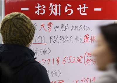 日本北海道札幌市的JR札幌站，一塊告示牌顯示，由於大雪，部分列車停駛。(美聯社/達志影像)