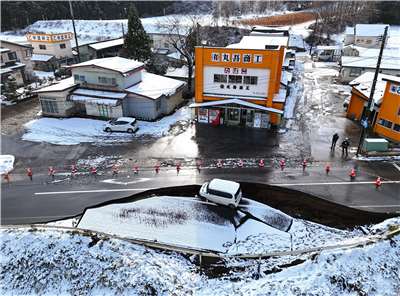 日本青森縣8日發生強烈地震，一輛汽車墜入坍塌的道路上。資料照。(美聯社/達志影像)