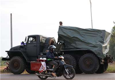 泰柬衝突再起。圖為一名男子駕車經過駛向邊境的軍車。