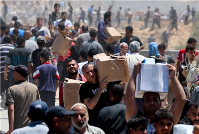 以色列30日宣布將從明年起，暫停向20多個人道組織發放在加薩走廊(Gaza Strip)的運作許可。圖為巴勒斯坦人從人道組織取得援助物資資料照。(路透社/達志影像)