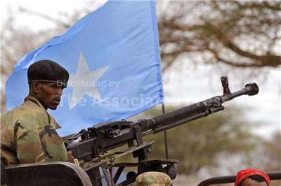 索馬利亞首都摩加迪休(Mogadishu)今天(25日)將舉行市政選舉。圖為一名索馬利亞士兵站在一幅索馬利亞國旗前方維持秩序。資料照片(路透社/達志影像)