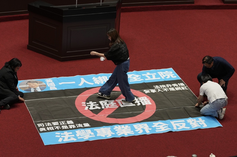 民眾黨立法院黨團27日在立法院會提案變更議程，要
求27日審議涉及是否開放法庭直播的法院組織法草
案，民進黨立法院黨團批評不應把法庭當直播秀場，
遂行特定個案全民公審的政治意圖，要求立法院長韓
國瑜應出面協商，反對倉促修法。圖為綠委在立法院
議場貼海報表達訴求。(圖 : 中央社)
