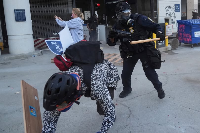 圖為一名抗議者試圖躲避國土安全部官員的追捕。