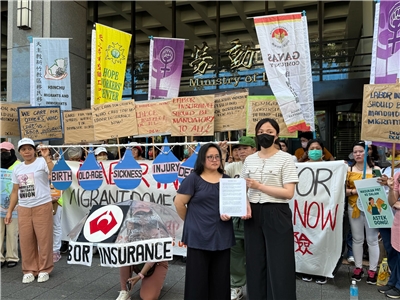 勞動部勞動發展署專員蔡佳儒(右)接下移工團體陳情書。(謝佳興 攝)