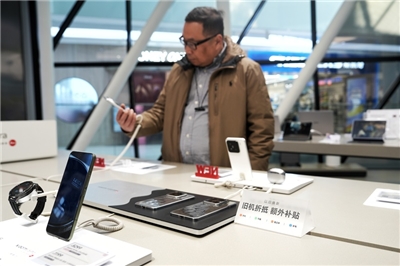消費者在北京一家門市選購手機。（中新社提供）