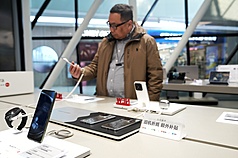 圖為3月5日，消費者在北京一家門市選購手機。（中新社提供）