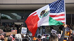 洛杉磯數百人群眾聚集在聯邦政府大樓前，抗議移民
暨海關執法局（ICE）突襲掃蕩非法移民，群眾當中
有人手持墨西哥與美國國旗的拼貼旗幟，訴求墨裔族
群在美國的權益。
