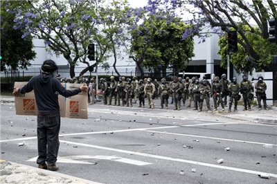 美國移民及海關執法局6日在加州派拉蒙市對非法移民進行突襲搜查後，美國邊境巡邏隊與抗議者發生衝突。(AFP)