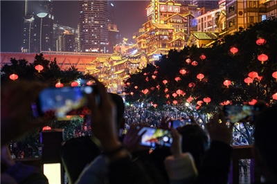 圖為重慶洪崖洞璀璨夜景吸引眾多遊客前來打卡拍照。（中新社提供）
