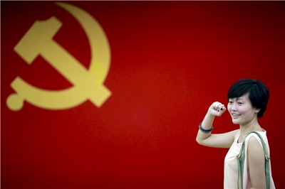 圖為2012年在上海的中共第一次代表大會會場，一名女子在中國共產黨黨旗下擺出宣誓姿勢。示意圖。(美聯社/達志影像)