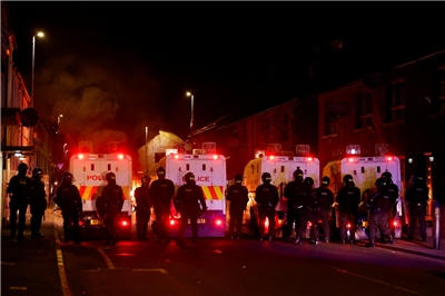 北愛爾蘭城鎮巴利米納(Ballymena)10日連續第二晚動亂，警察在一輛燃燒的車輛前排成一排。(路透社/達志影像)
