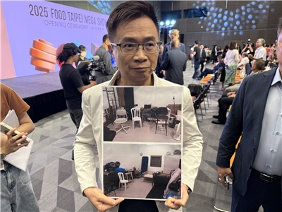 貿協董事長黃志芳秀出貿協以色列台貿中心主任林珮琤所拍的照片，展示以色列當地大樓的防空避難室樣貌。(謝佳興 攝)